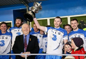 Waterford captain Thomas O’Gorman lifts the McGrath Cup after the presentation by Munster Council Chairman Robert Frost at Fraher Field in Saturday last.