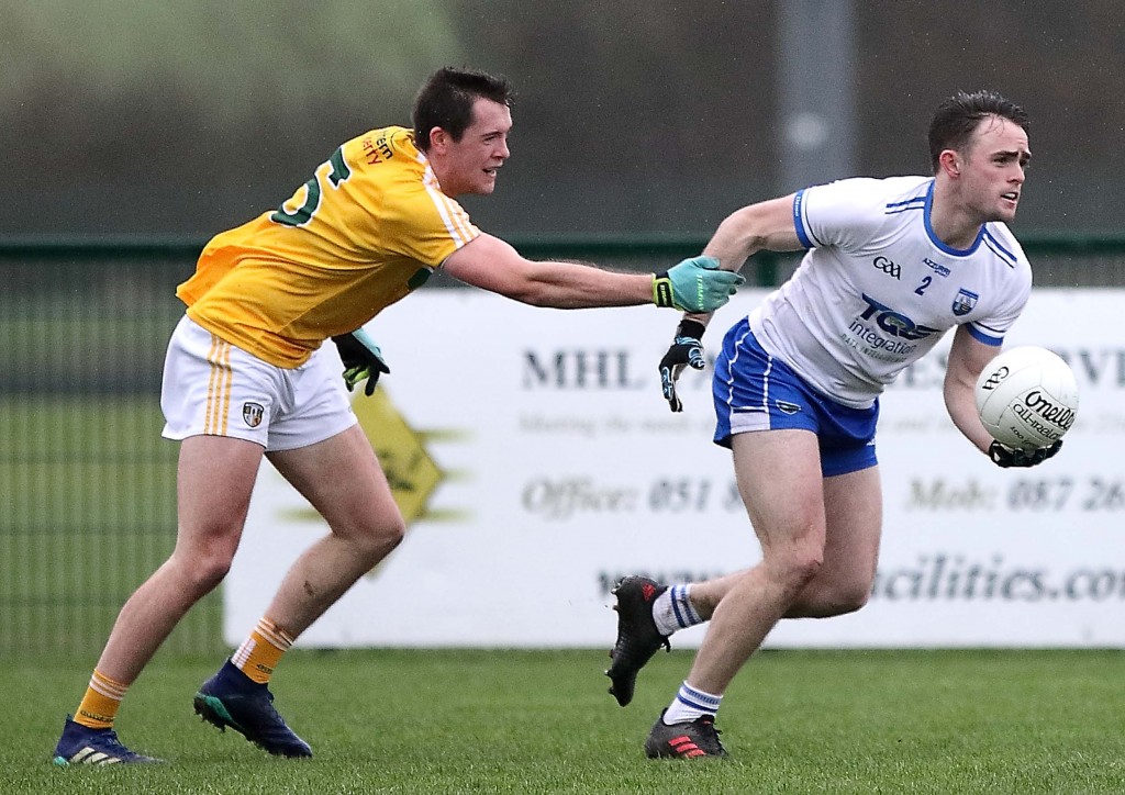 Waterford’s Sean O’Donovan is dragged back by Antrim’s Ryan Murray.